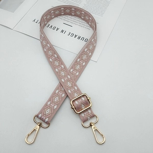 Detail of adjustable wide jacquard strap with pink brown geometric pattern and gold clips