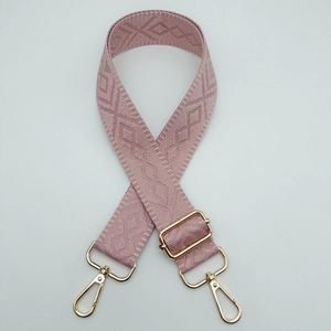 Close-up of pink geometric diamond weave pattern and adjustable gold metal buckle on strap