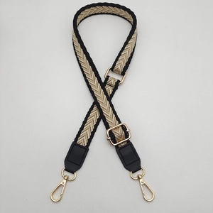 Adjustable woven crossbody strap with black and beige chevron pattern and gold buckles