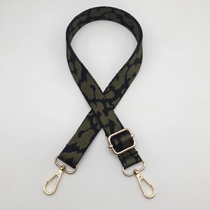 Close-up of leopard pattern strap with army green webbing and golden metal buckles