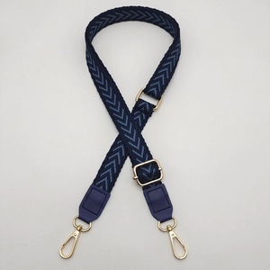 Close-up of adjustable dark blue herringbone strap with gold metal lobster clasps and buckles