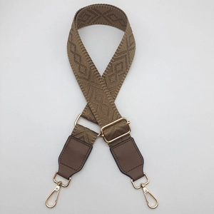 Detail of adjustable wide shoulder strap with jacquard geometric patterns and gold metal hooks