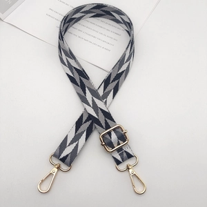 Adjustable geometric woven bag strap with gold metal hooks and arrow pattern design