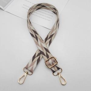 Detail of adjustable geometric patterned fabric shoulder strap with gold metal swivel hooks