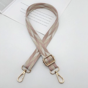Detail of colorful geometric wave pattern woven bag strap with golden metal swivel hooks