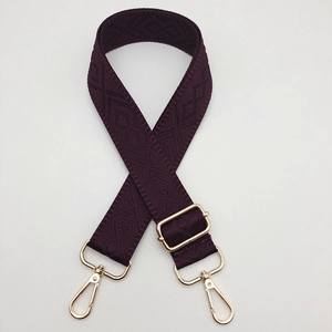 Close-up of deep purple wide woven strap with geometric diamond patterns and gold metal hooks
