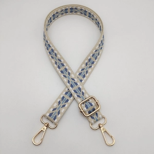 Close-up of adjustable nylon woven shoulder strap with retro geometric patterns and gold hooks