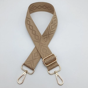 Detail of khaki adjustable bag strap with diamond pattern weaving and golden metal hooks