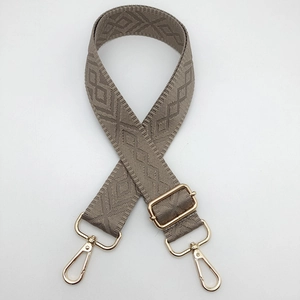 Detail of adjustable khaki strap with geometric diamond weave and gold metal hooks