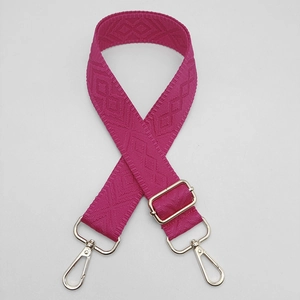 Detail view of rose red geometric jacquard bag strap with silver metal swivel hooks