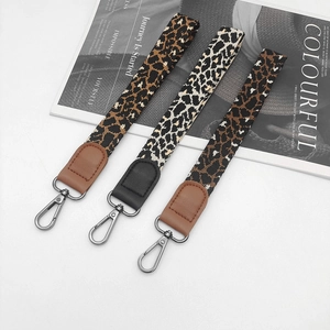 Detailed view of three leopard print wrist lanyards with leather accents and swivel hooks