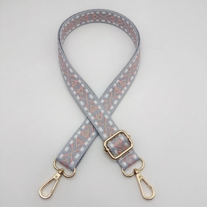 Detail of adjustable woven nylon strap in pink and grey with gold metal hooks