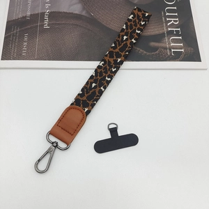 Detail of leopard print phone wrist strap with leather wrap and grey metal lobster clasp