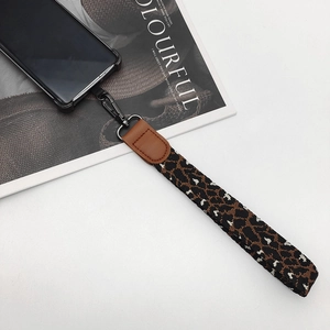 Close-up of leopard pattern phone lanyard with brown leather end and metal spring hook