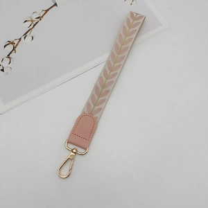Detail of woven wrist strap with pink leaf patterns and golden thread embroidery