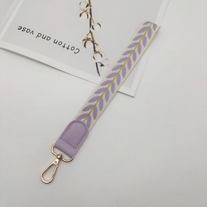 Detail of leaf pattern phone lanyard with purple embroidery and golden metal clasp