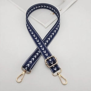 Detail of navy blue nylon arrow pattern strap with light gold swivel snap hooks
