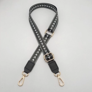 Detail of 2.5cm adjustable bag strap with black grey arrow pattern and gold hooks