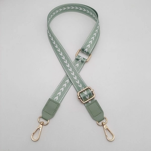 Detail view of adjustable woven bag strap in sage green with white chevron pattern