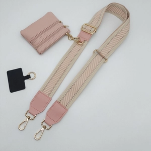 Dettaglio tracolla regolabile per telefono con pochette rosa e fibbie in metallo oro