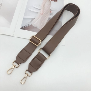 Detail of brown PU leather adjustable shoulder strap with gold lobster clasps and grain texture