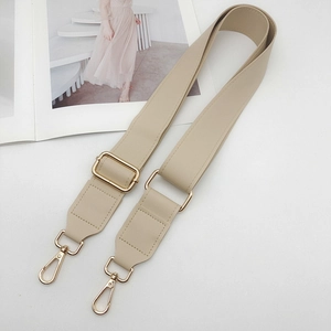 Macro detail of khaki PU leather bag strap with fine stitching and gold metal buckle