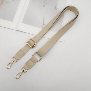 Close-up of adjustable beige PU leather shoulder strap with elegant gold metal hardware
