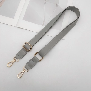 Close-up of adjustable grey PU leather shoulder strap with golden metal lobster clasps