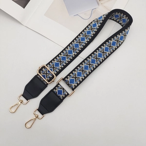 Detail of woven ethnic bag strap with geometric patterns and gold metal swivel hooks