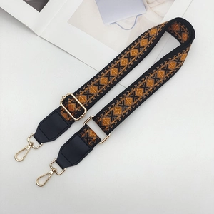 Detail of adjustable bohemian jacquard purse strap with gold lobster clasps and geometric patterns