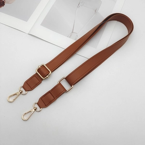 Close-up of adjustable caramel brown leather strap with golden metal spring hooks