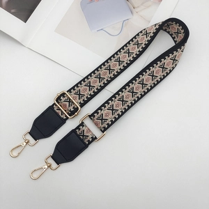 Close-up of ethnic geometric weave bag strap with golden hooks and leather ends