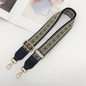 Detailed close-up of ethnic jacquard weave patterns and gold rotating buckles on straps
