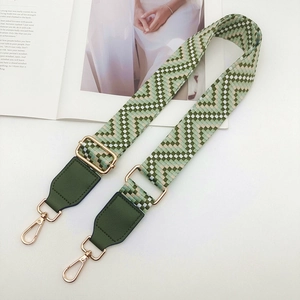 Gros plan de la bandoulière ethnique avec motif géométrique vert et boucles dorées