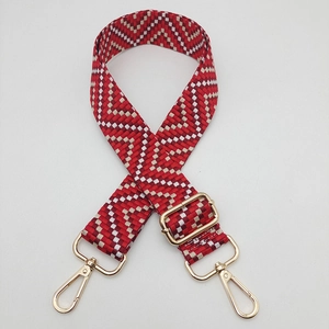 Detail of red and white geometric woven strap with adjustable gold rotating buckle