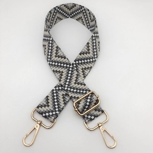 Detail of adjustable geometric ethnic strap with golden metal lobster clasps for bags