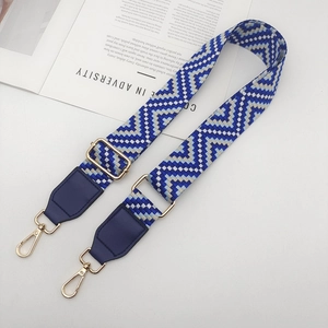Détail de la bandoulière tissée bleue et blanche avec crochets en métal doré