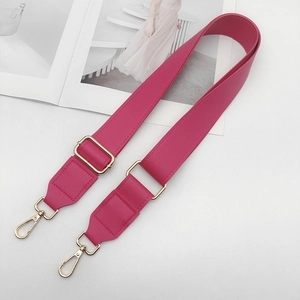 Close-up of magenta adjustable PU leather bag strap with gold metal hooks and pebble texture