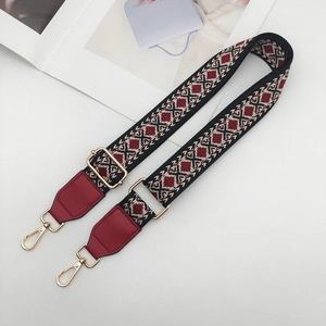 Close-up of ethnic jacquard wide bag strap with vintage geometric patterns and gold hooks