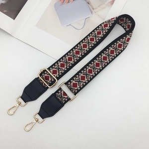 Close-up of ethnic woven bag strap with geometric patterns and golden lobster clasp