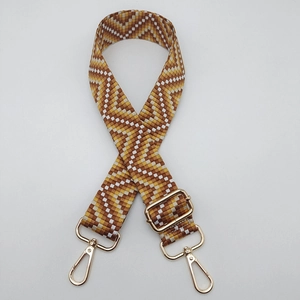 Macro shot of geometric weave strap with golden metal swivel hooks and adjustable buckle