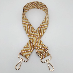 Detail of yellow chevron woven strap with adjustable gold lobster clasps and metal buckle