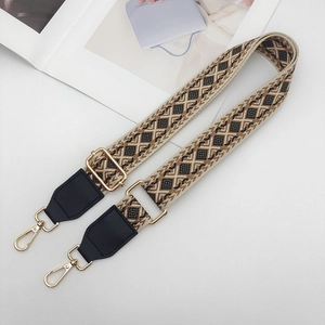 Close-up of ethnic geometric jacquard strap with gold metal hooks and leather trim