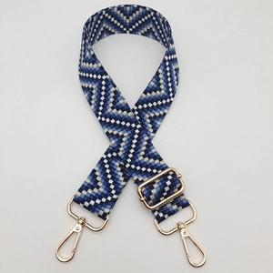 Detail of adjustable geometric ethnic strap with blue patterns and gold metal lobster clasps