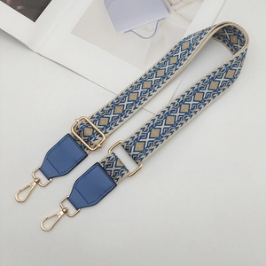 Close-up of ethnic geometric jacquard strap with blue leather ends and gold metal hooks
