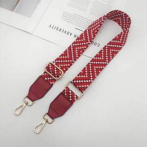 Détail de la bandoulière ethnique large avec motifs de cœur rouges et boucles dorées