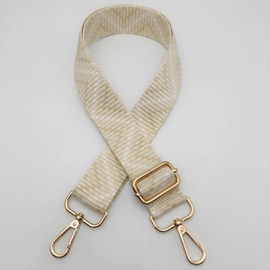 Detail of adjustable beige chevron woven shoulder strap with gold metal lobster clasps