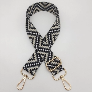 Detail view of woven geometric guitar strap with gold lobster clasps and adjustment buckle