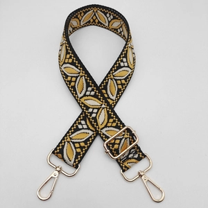 Detail of adjustable woven guitar strap with leaf pattern and gold metal lobster clasps