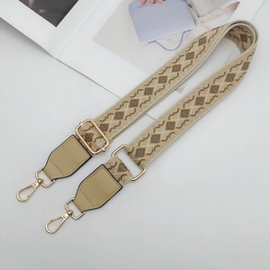 Detail of wide ethnic woven bag strap with geometric patterns and gold metal buckles